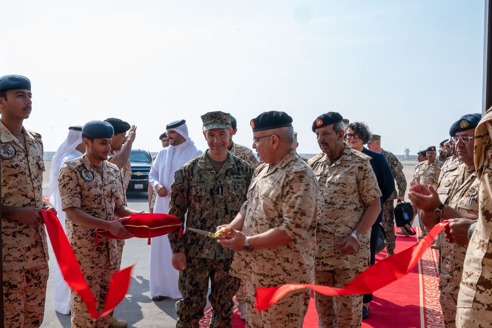MANAMA, Bahrain (Dec. 1, 2025) His Royal Highness Prince Salman bin Hamad Al-Khalifa, Crown Prince, Deputy Supreme Commander and Prime Minister of Bahrain, cuts a ribbon with U.S. Navy Adm. Brad Cooper, commander of U.S. Central Command, commemorating the opening of the Combined Command Post at Ras Al Bar Camp. The event marked the opening of a new Combined Command Post for air defense staffed by Bahrain and U.S. forces.  (U.S. Navy photo by Mass Communication Specialist 2nd Class Lindsay Lair)