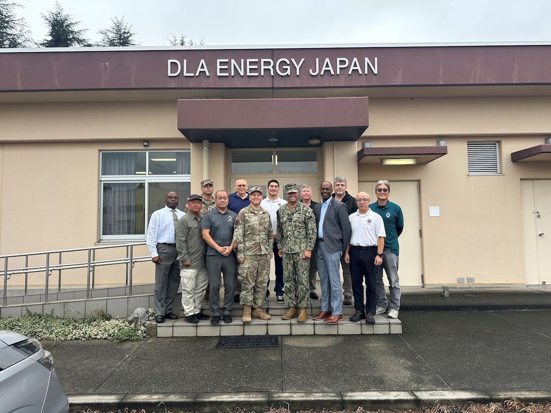 RDML Bresnihan (center right) is greeted by Air Force Maj. Baker (center left) and DLA Energy Japan staff outside the headquarters building at Yokota Air Base.