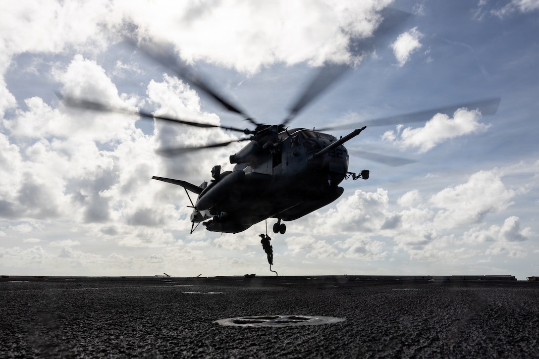 A U.S. Marine with Maritime Special Purpose Force, 22nd Marine Expeditionary Unit (Special Operations Capable), fast-ropes from a CH-53E Super Stallion helicopter during fast rope insertion training aboard San Antonio-class amphibious transport dock ship USS San Antonio (LPD 17) while underway in the Caribbean Sea, Nov. 25, 2025. U.S. military forces are deployed to the Caribbean in support of the U.S. Southern Command mission, Department of War-directed operations, and the president’s priorities to disrupt illicit drug trafficking and protect the homeland. (U.S. Marine Corps photo)