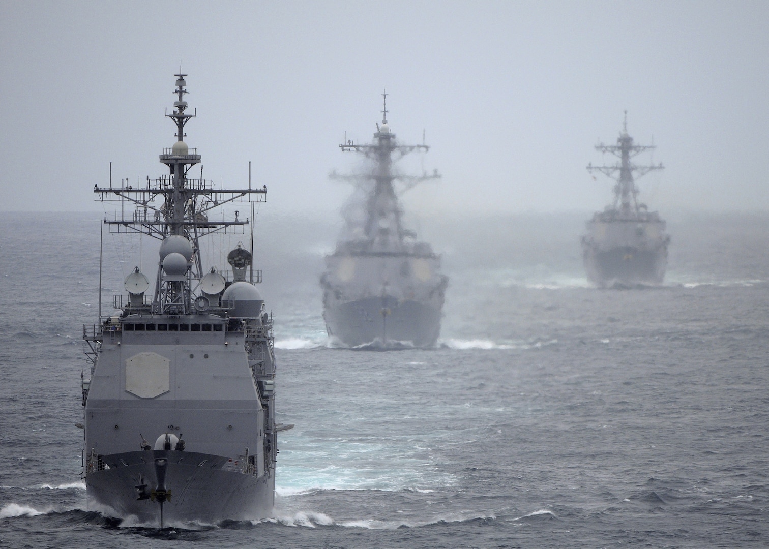 The Ticonderoga-class guided missile cruiser USS Cape St. George (CG 71) leads the Arleigh Burke-class guided missile destroyers USS Momsen (DDG 92) and USS Sterett (DDG 104) trail the Nimitz-class aircraft carrier USS Abraham Lincoln (CVN 72) during a training exercise. Cape St. George is equipped with four AN/SPG-62 Fire Control Radars, which are mounted high on the vessel to ensure a clear line of sight. These radars are arranged to provide nearly 360-degree engagement capability for the Aegis Combat System. (U.S. Navy photo by Petty Officer 2nd Class Colby Neal)