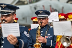 People in military uniforms play musical instruments