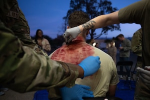 U.S. Air Force pararescuemen assigned to the 48th Rescue Squadron apply moulage before an exercise scenario , during Mosaic Lightning 26-1 at Davis-Monthan Air Force Base, Arizona, Nov. 13, 2025. Moulage was applied to simulated casualties to create realistic injuries, allowing first responders to practice treating patients and responding appropriately to each scenario. (U.S. Air Force photo by Airman 1st Class Jaden Kidd)