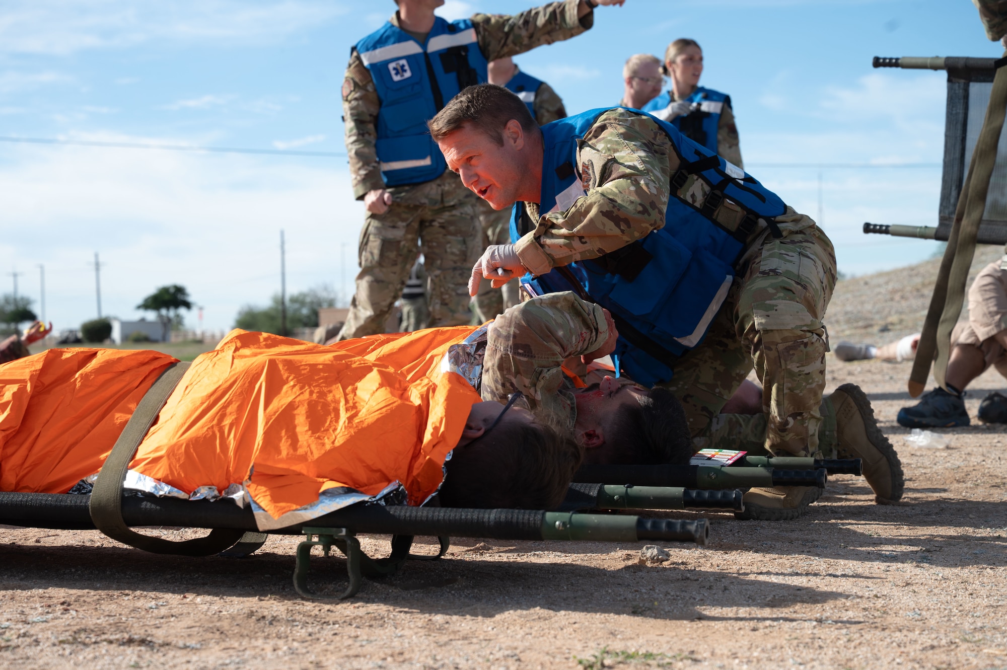 A U.S. Air Force Airman with the 355th Medical Group secures a simulated casualty to a stretcher during an exercise scenario as part of Mosaic Lightning 26-1 at Davis-Monthan Air Force Base, Arizona, Nov. 13, 2025. The paramedics are trained to perform emergency medical treatment such as patient triage, CPR and bleeding control. (U.S. Air Force photo by Airman 1st Class Jaden Kidd)