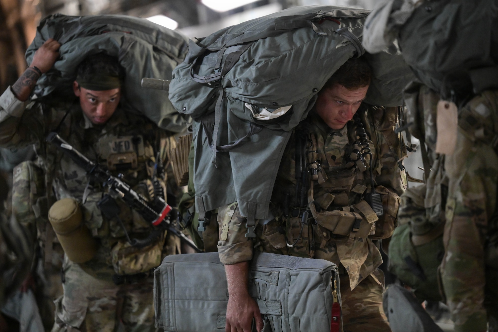U.S. Army soldiers carrying equipment onto a U.S. Air Force aircraft.