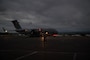 A U.S. Air Force soldier martialing an aircraft at night.