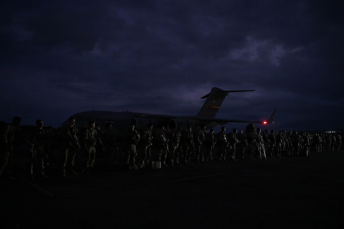 Soldiers in formation on a flightline.