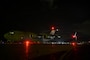 Two U.S. Air Force aircraft sitting on a flightline at night.