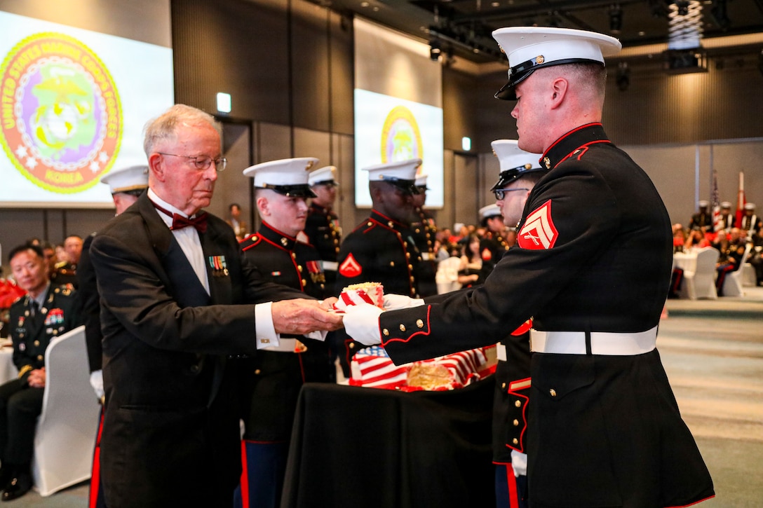 U.S. Marine Corps Maj. Chris Ray, the oldest marine present, passes the first piece of the birthday cake to U.S. Marine Corps Cpl. Trent M. Crawford, a comptroller chief with United States Marine Corps Forces, Korea and the youngest marine present, during MARFORK’s 250th Marine Corps birthday ball in Seoul, South Korea, Nov. 21, 2025. Founded on November 10, 1775, the United States Marine Corps has served our nation honorably in every clime and place for 250 years. Throughout 2025, Marines across the globe will celebrate the 250th birthday of the Corps, commemorating service, sacrifice, and priding themselves on living ‘Semper Fidelis’ or ‘Always Faithful’ to their nation and to each other. (U.S. Army photo by Cpl. Park Seongho)