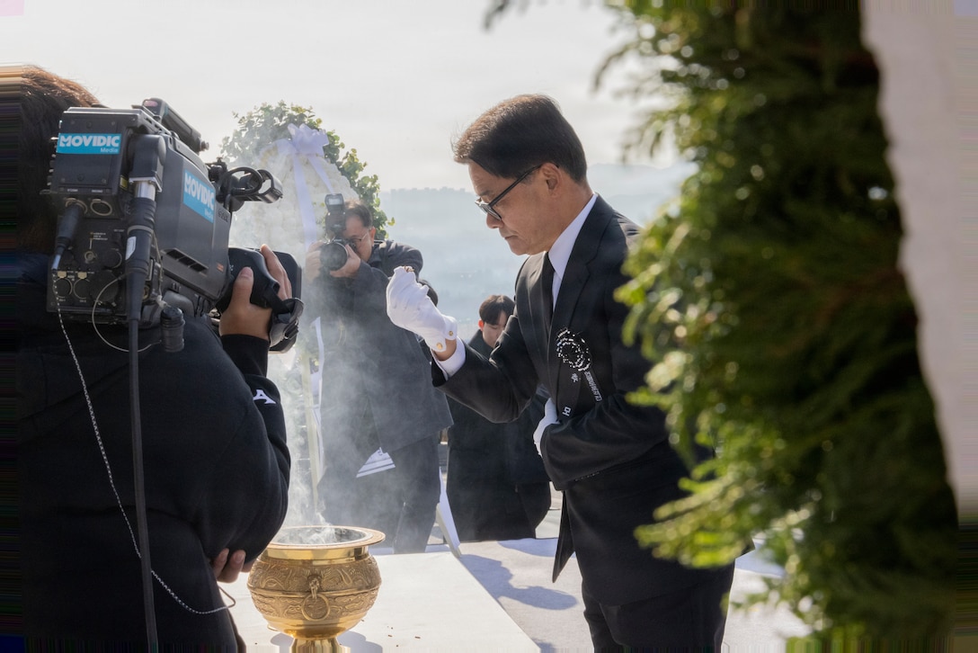 A Republic of Korea government official places incense powder into a flame to pay respect to the fallen during the Republic of Korea memorial ceremony for the 15th anniversary of the Bombardment of Yeonpyeong to honor the fallen ROK Marines and their unwavering actions in defense of their country, on Nov. 23, 2025. On Nov. 23, 2010, upon receiving North Korean artillery fire on Yeonpyeong Island, ROK Marine Corps forces responded swiftly and decisively with artillery counterfire to successfully defend the island in what is known today as the Bombardment of Yeonpyeong. (U.S. Marine Corps photos by Cpl. Simon Saravia)