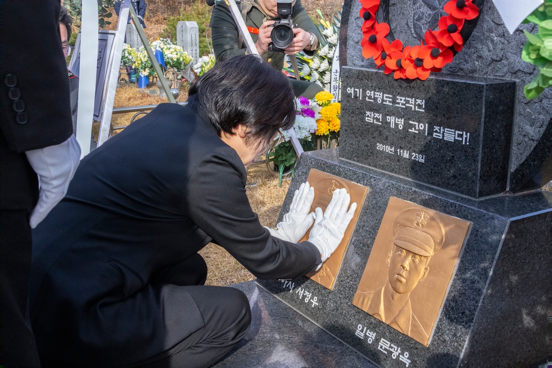 The mother of Republic of Korea Marine Corps Staff Sgt. Suh Jung-woo kneels at the foot of her son’s headstone during a memorial ceremony for the 15th anniversary of the Bombardment of Yeonpyeong to honor the fallen ROK Marines and their unwavering actions in defense of their country, on Nov. 23, 2025. On Nov. 23, 2010, upon receiving North Korean artillery fire on Yeonpyeong Island, ROK Marine Corps forces responded swiftly and decisively with artillery counterfire to successfully defend the island in what is known today as the Bombardment of Yeonpyeong. (U.S. Marine Corps photos by Cpl. Simon Saravia)
