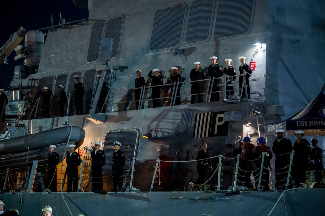Sailors man the rails during a sea and anchor evolution aboard the Arleigh Burke-class guided-missile destroyer USS John Finn (DDG 113) as the ship returns to Commander Fleet Activities Yokosuka, Nov. 3, 2025.
