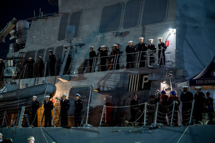 Sailors man the rails during a sea and anchor evolution aboard the Arleigh Burke-class guided-missile destroyer USS John Finn (DDG 113) as the ship returns to Commander Fleet Activities Yokosuka, Nov. 3, 2025.