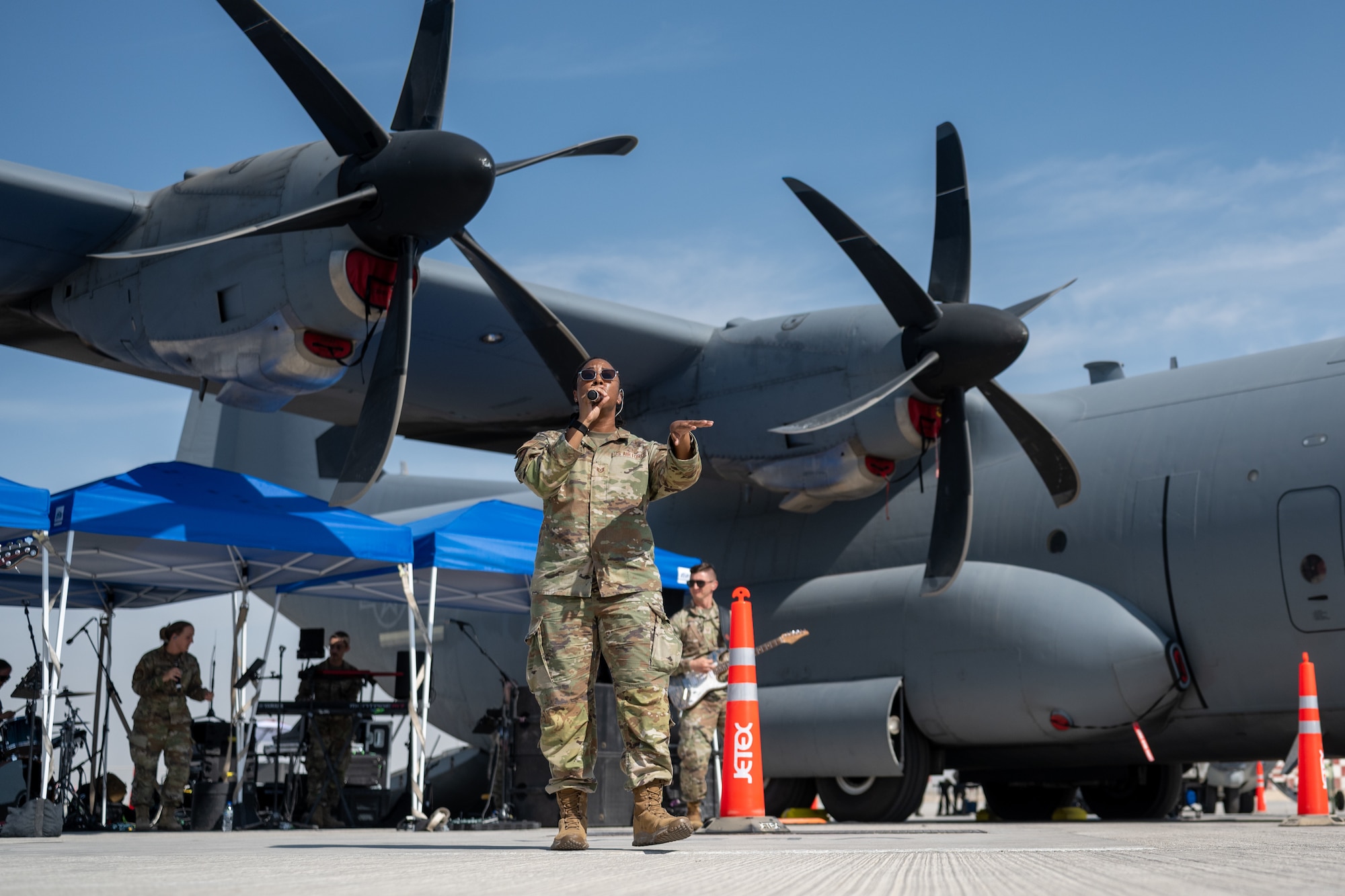 Person in uniform sings in front of plane