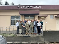 RDML Bresnihan (center right) is greeted by Air Force Maj. Baker (center left) and DLA Energy Japan staff outside the headquarters building at Yokota Air Base.