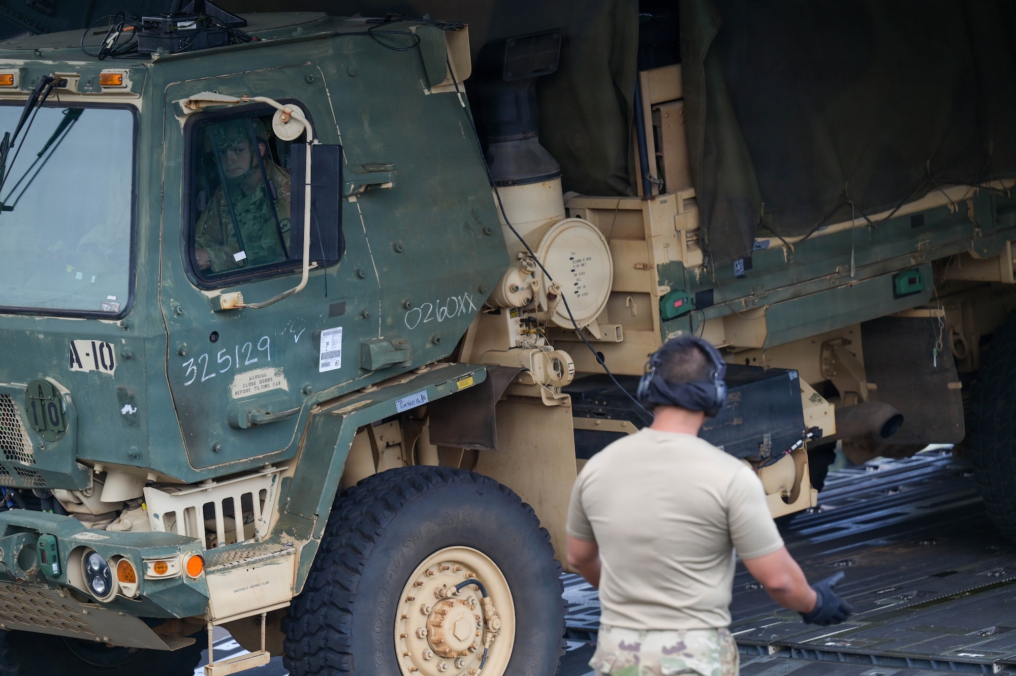 U.S. Air Force unload U.S. Army equipment off an aircraft.
