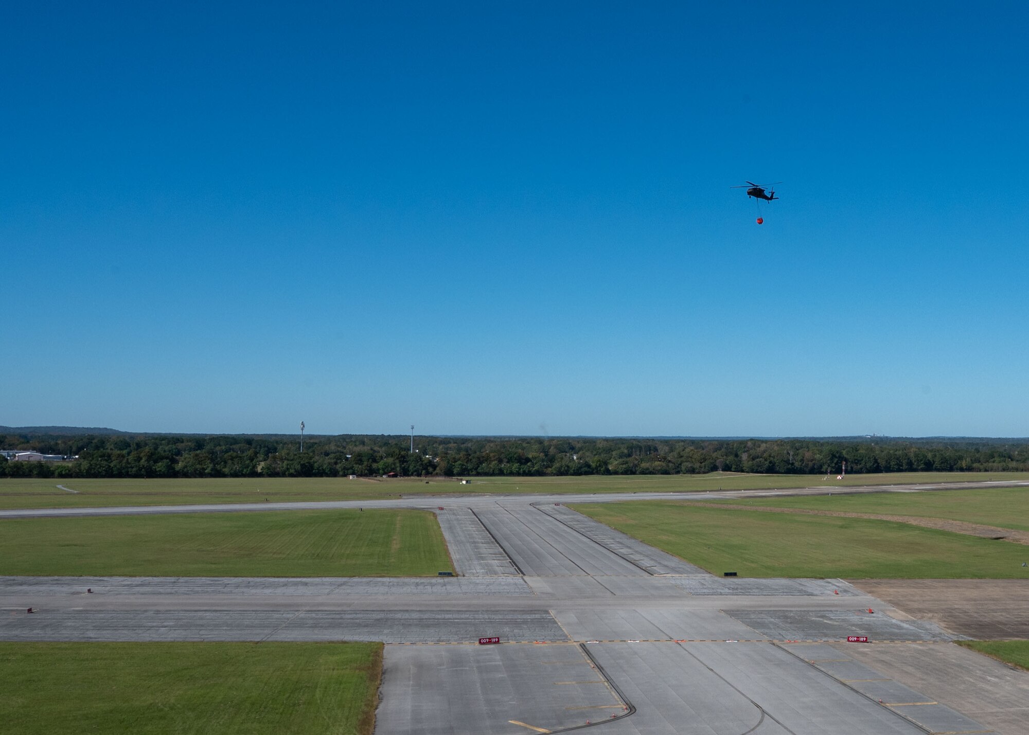 An MH-139A Grey Wolf helicopter from the 908th Flying Training Wing carries a water bucket over Maxwell Air Force Base, Alabama, during a training exercise, Oct. 22, 2025.