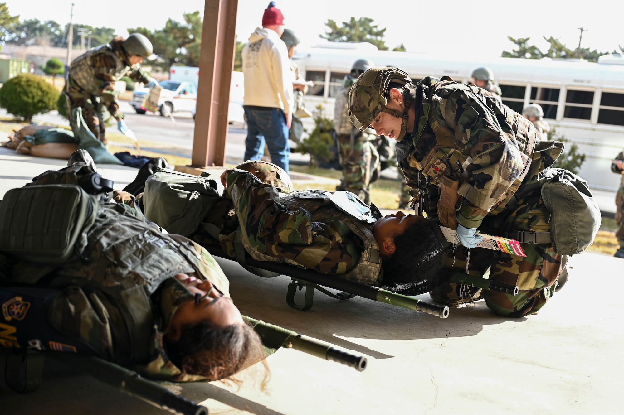A woman helps a patient on the ground.