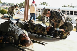 A woman helps a patient on the ground.