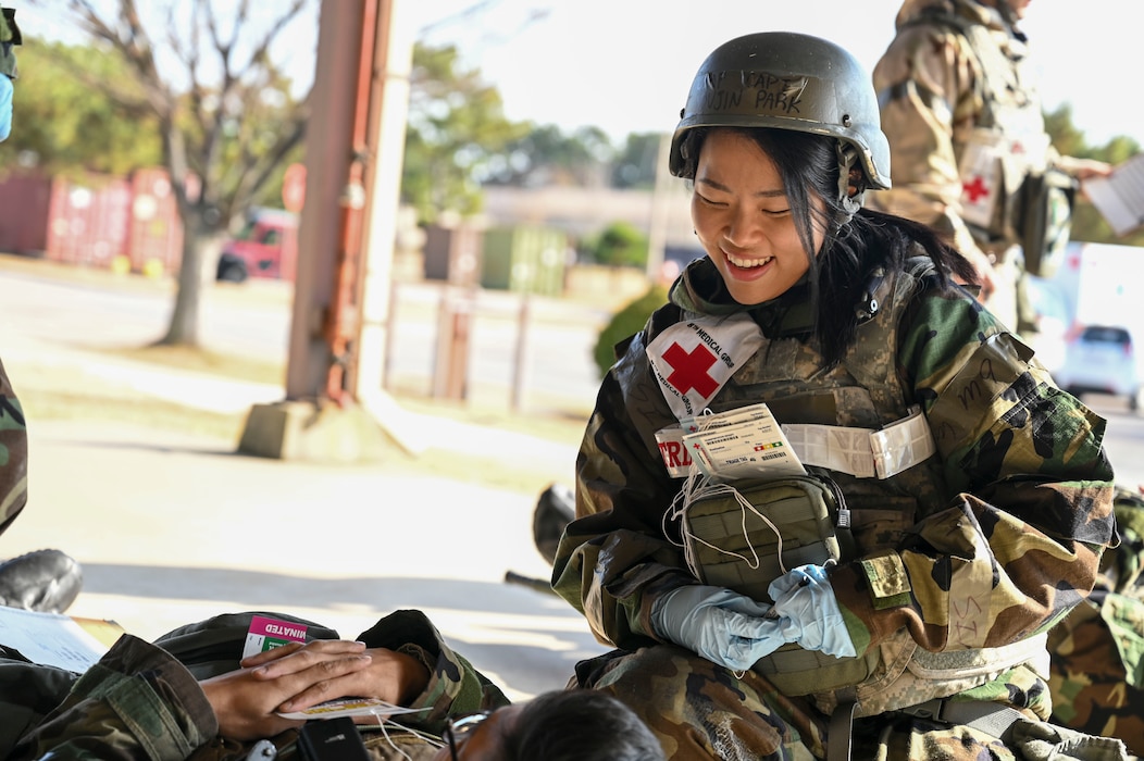 A woman helps a patient on the ground.