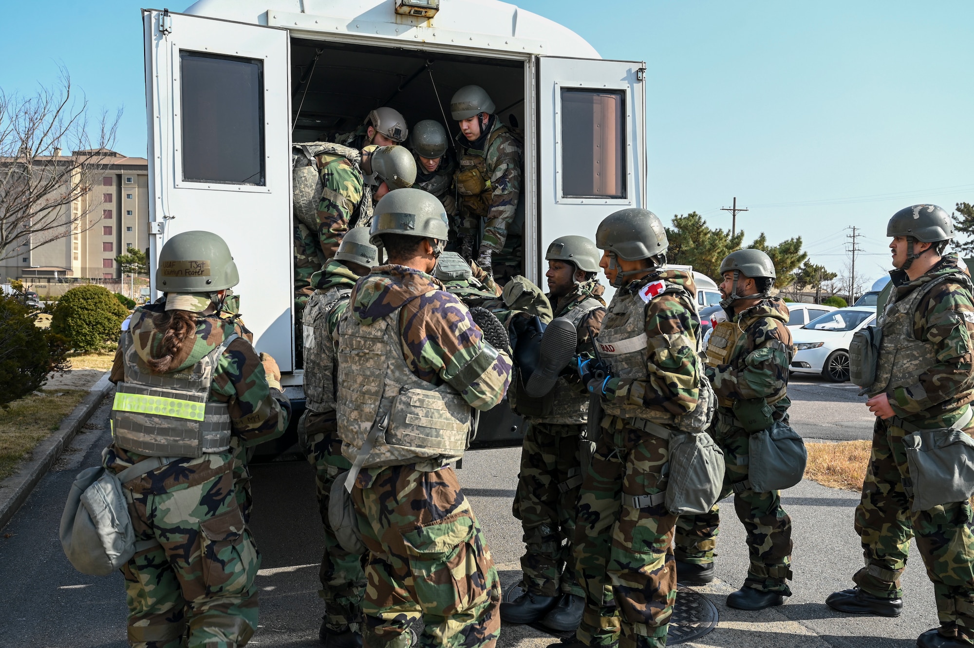 Airmen unload a stretcher from a bus.