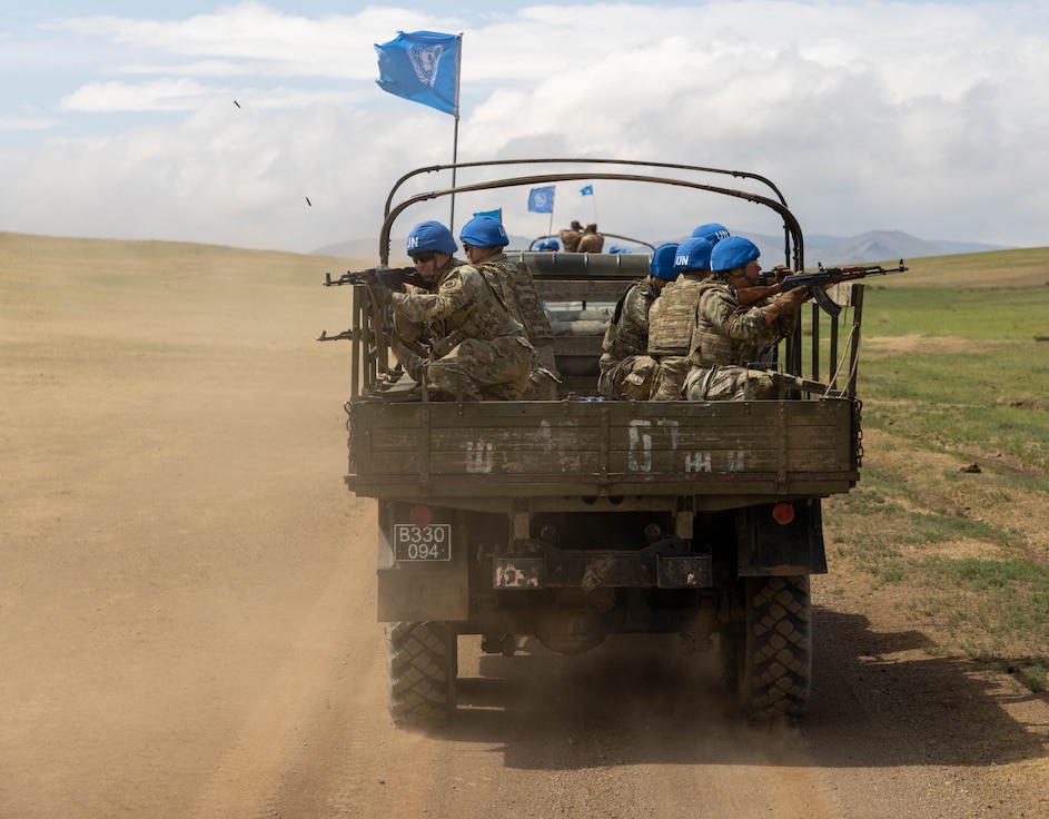 U.S. Army Soldiers assigned to 390th Military Police Battalion, 11th Military Police Brigade, 200th Military Police Command, ride in the back of a Mongolian Armed Forces ZIL-131 Utility Truck during a simulated U.N. convoy mission, during Khaan Quest, on June 17, 2025, at Five Hills Training Area, Mongolia. U.S. Army Soldiers were provided small arms by the Mongolian Armed Forces to facilitate U.N. training. Khaan Quest is an annual, multinational and multicomponent training exercise led by the Mongolian Armed Forces designed to promote regional peace and security. (U.S. Army photo by Staff Sgt. Tristan Moore)
