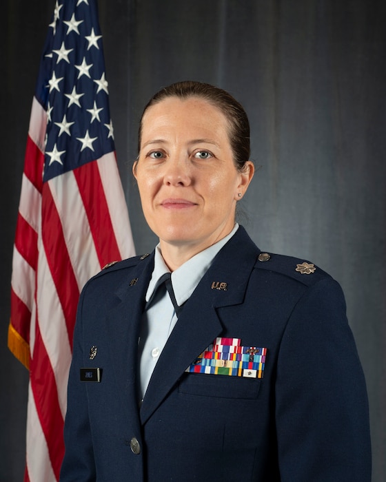 Lt. Col. Barbara Jones, commander of the 157th Medical Group, pose for an official portrait in service dress blue uniform alongside a flag in a photo studio at Pease Air National Guard Base, New Hampshire, September 17, 2025. Lt. Col. Jones was assigned command of the 157th MDG 9 August 2025. (U.S. Air National Guard photo by Tech. Sgt. April S. Jackson)