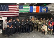 Members of the New York Police Department's Emergency Services Unit and Airmen from the New York Air National Guard's 103rd Rescue Squadron, assigned to the 106th Rescue Wing, pose for a group photo at Floyd Bennett Field, Brooklyn, N.Y., Oct. 23, 2025.