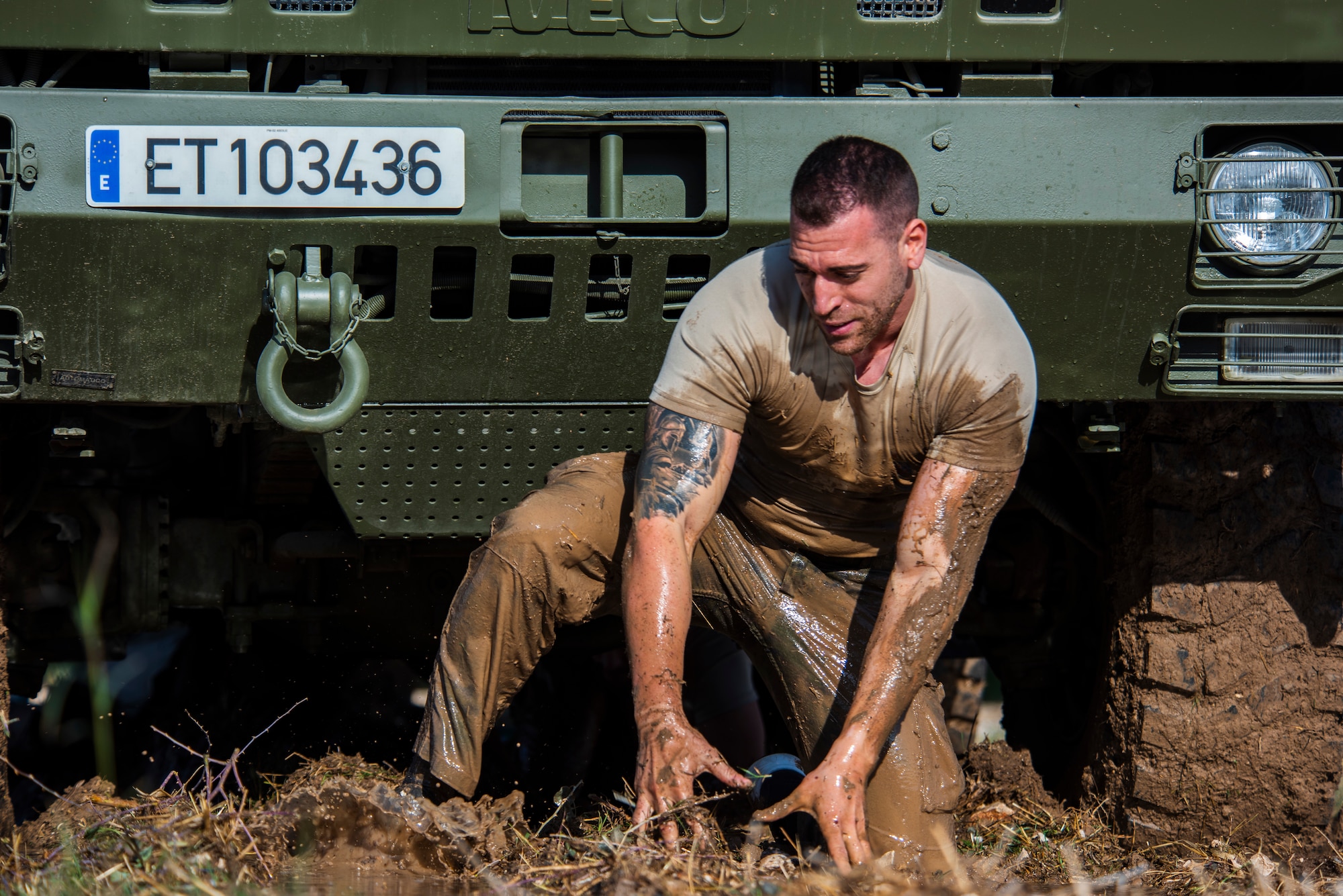 A Spanishservice member emerges from a mud obstacle during an endurance challenge