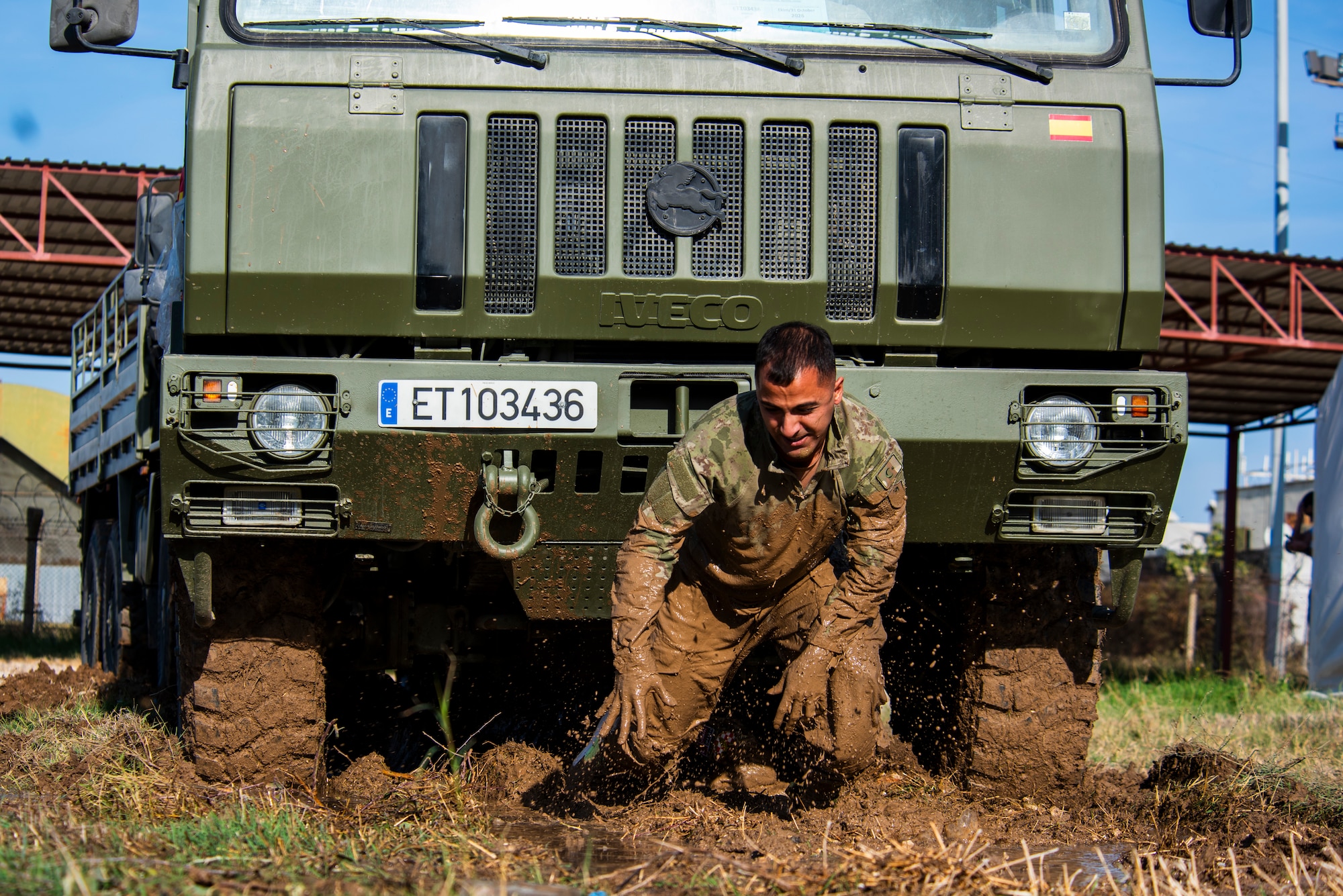 A Turkish Air Force service member emerges from a mud obstacle during an endurance challenge