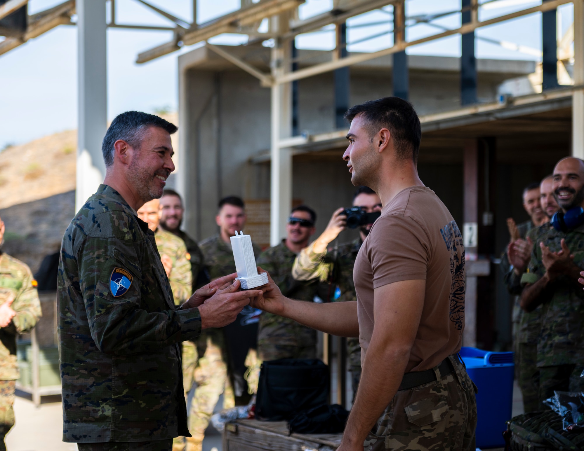 A Spanishservice member presents the first-place award to Turkish Air Force members