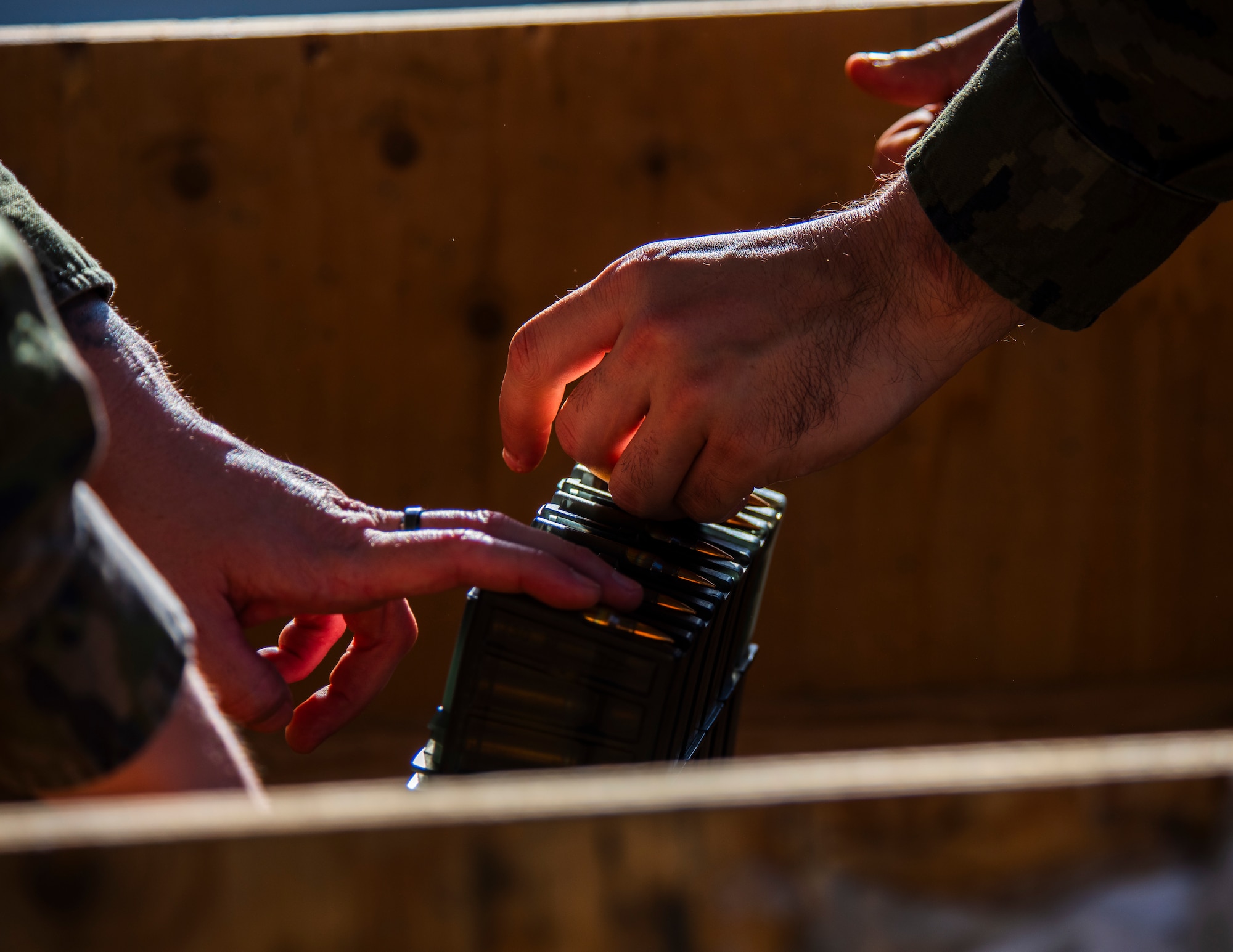 Spanish service members prepare ammunition during a shooting competition