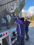 New York Army National Guard Maj. Jonathan Mattingly helps lift a donated Christmas tree from FedEx employee Mark Burby during the loadout of 150 trees at Ellms Family Farm in Ballston Spa, N.Y., Dec.1, 2025. The tree loadout was part of the annual volunteer effort by individuals to support Trees for Troops. Photo by Richard Goldenberg.
