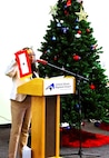 American Gold Star Families, Inc., President Frances Maddox holds up a Blue Star Flag while explaining the history of the Gold Star during the American Gold Star Families’ Fallen Heroes Tree of Honor Tree Lighting Ceremony.