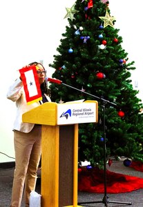 American Gold Star Families, Inc., President Frances Maddox holds up a Blue Star Flag while explaining the history of the Gold Star during the American Gold Star Families’ Fallen Heroes Tree of Honor Tree Lighting Ceremony.