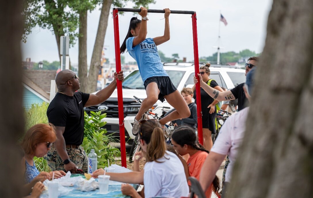 A member of the local community participates in the Marine Corps pull-up challenge during Coast Guard Festival at Grand Haven, Michigan, July 28, 2025. Coast Guard Festival is an annual event that provides the Marines a juncture to interact with the local community and educate prospects on Marine Corps opportunities. (U.S. Marine Corps photo by Sgt. Israel Sheber)