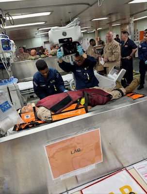 250531-N-N1574-1001 CARIBBEAN SEA (May 31, 2025) Cmdr. Nicholas Digeorge, Hospital Corpsman 2nd Class Wudineh Melketsadek, and Hospital Corpsman 3rd Class Thai Nguyen, assigned to the Mercy-class hospital ship USNS Comfort (T-AH 20), demonstrate X-ray capabilities for a mass casualty drill that took place during a Commander’s Readiness Evaluation (CRE) while underway aboard the USNS Comfort, for Continuing Promise 2025, May 31, 2025. During the drill, the department identified constraints with many of their resources and processes which caused them to initiate a “Get Real, Get Better” process improvement initiative. Comfort provides rapid, mobile, and large-scale medical support. (U.S. Navy courtesy photo)
