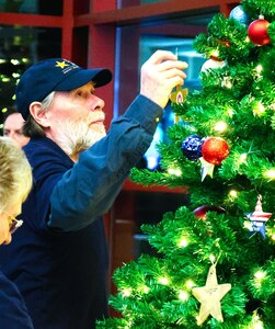 A Gold Star Family member affixes an ornament with the name of a fallen service member during the American Gold Star Families’ Fallen Heroes Tree of Honor Tree Lighting Ceremony.