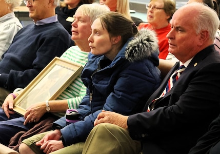 Janet Ulbrich holds a photograph of her uncle, U.S. Army Sgt. Harold W. TeVoert, with her daughter, Karen Ulbrich and Bloomington (IL) Mayor Dan Brady.