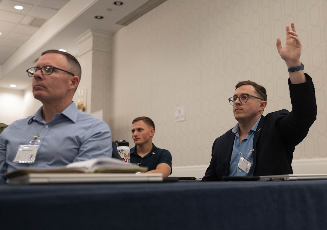 U.S. Marine Corps Gunnery Sgt. Joshua Weight, assigned to the Marine Innovation Unit, raises his hand to ask a question during a town hall meeting in White Plains, New York, Nov. 20, 2025. During the town hall, Brig. Gen. David K. Winnacker and Sgt. Maj. Russell D. Boley delivered remarks and answered questions from the Marine Innovation Unit. Established in 2022, the Marine Innovation Unit leverages the talent of the Marine Corps Reserve to accelerate the adoption of advanced capabilities, transform Naval Service capacity for technology employment, and retain and invest in Total Force human capital. (U.S. Marine Corps photo by Cpl. Kanoa Thomas)