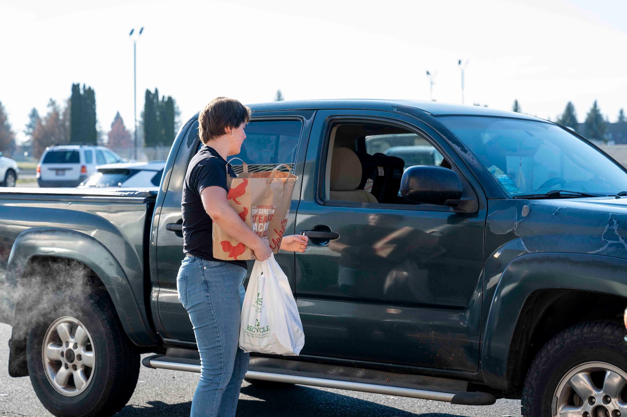 Airman hands out meal bundles to Airmen and families.