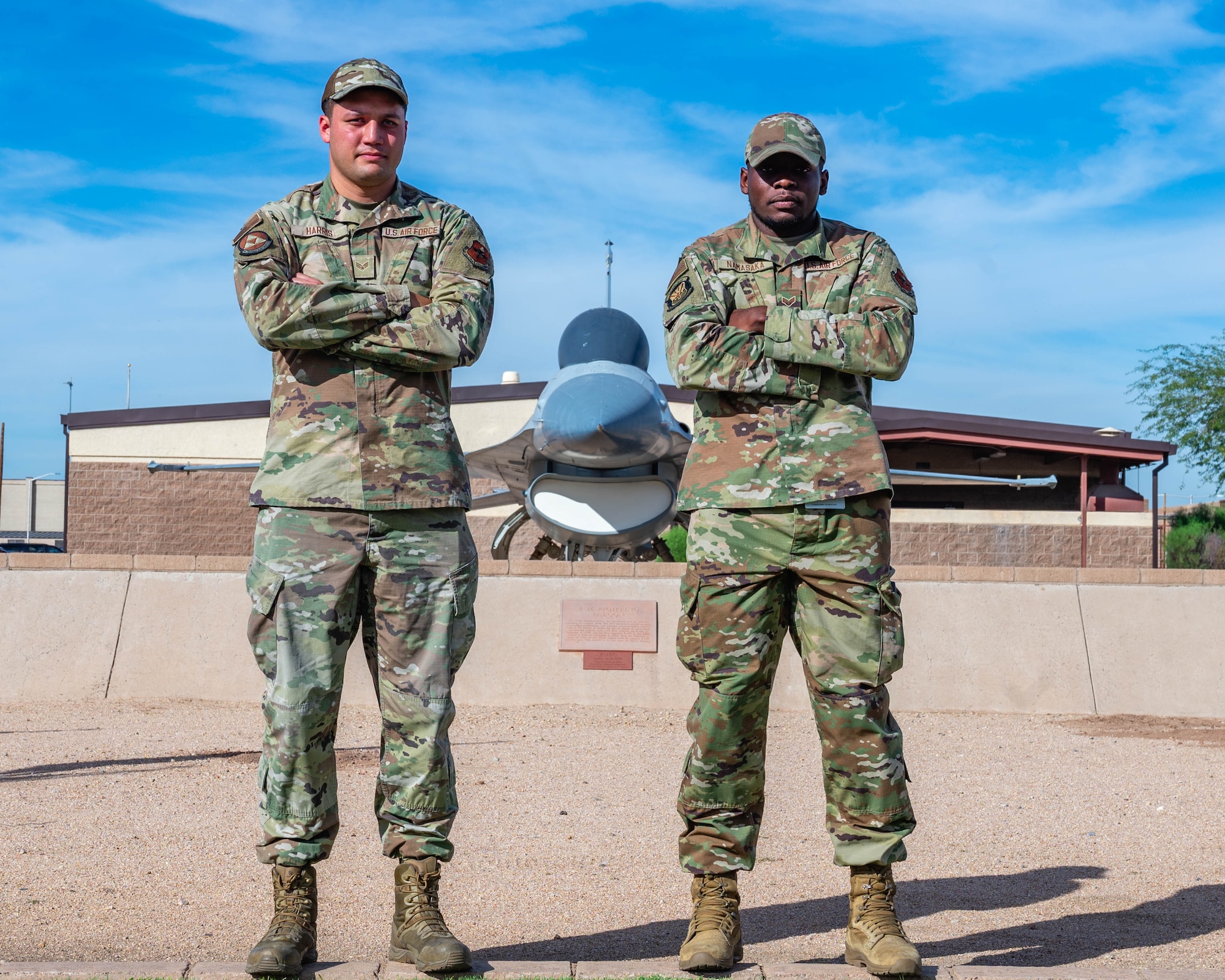 U.S. Air Force Senior Airman Ryan Namasaka, 56th Medical Support Squadron medical laboratory technician (right) and Senior Airman Calston Harris, 56th Equipment Maintenance Squadron armament maintenance technician (left), pose for a photo outside of the 56th Fighter Wing Headquarters, Nov. 4, 2025, at Luke Air Force Base, Arizona.