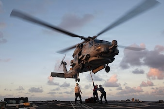 U.S. Sailors attach a cargo hook to an MH-60R Sea Hawk, assigned to the “Battle Cats” of Helicopter Maritime Strike Squadron (HSM) 73, on the flight deck of the Arleigh Burke-class guided-missile destroyer USS Wayne E. Meyer (DDG 108) in the Philippine Sea, Nov. 26, 2025.