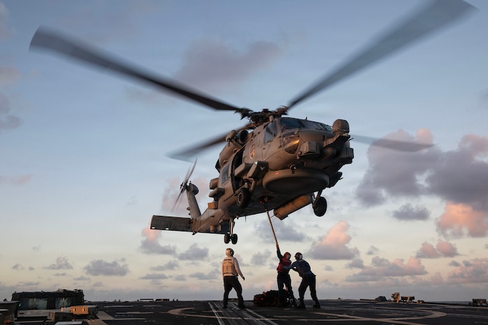 U.S. Sailors attach a cargo hook to an MH-60R Sea Hawk, assigned to the “Battle Cats” of Helicopter Maritime Strike Squadron (HSM) 73, on the flight deck of the Arleigh Burke-class guided-missile destroyer USS Wayne E. Meyer (DDG 108) in the Philippine Sea, Nov. 26, 2025.