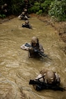 U.S. Marines with 7th Communication Battalion, III Marine Expeditionary Force Information Group, maneuver through chest deep water during Operation Odyssey Stormbreaker III at Jungle Warfare Training Center, Okinawa, Japan, Nov. 4, 2025.
