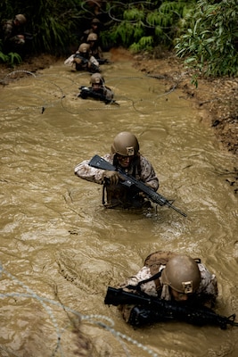 U.S. Marines with 7th Communication Battalion, III Marine Expeditionary Force Information Group, maneuver through chest deep water during Operation Odyssey Stormbreaker III at Jungle Warfare Training Center, Okinawa, Japan, Nov. 4, 2025.