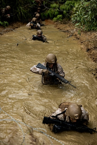 U.S. Marines with 7th Communication Battalion, III Marine Expeditionary Force Information Group, maneuver through chest deep water during Operation Odyssey Stormbreaker III at Jungle Warfare Training Center, Okinawa, Japan, Nov. 4, 2025.