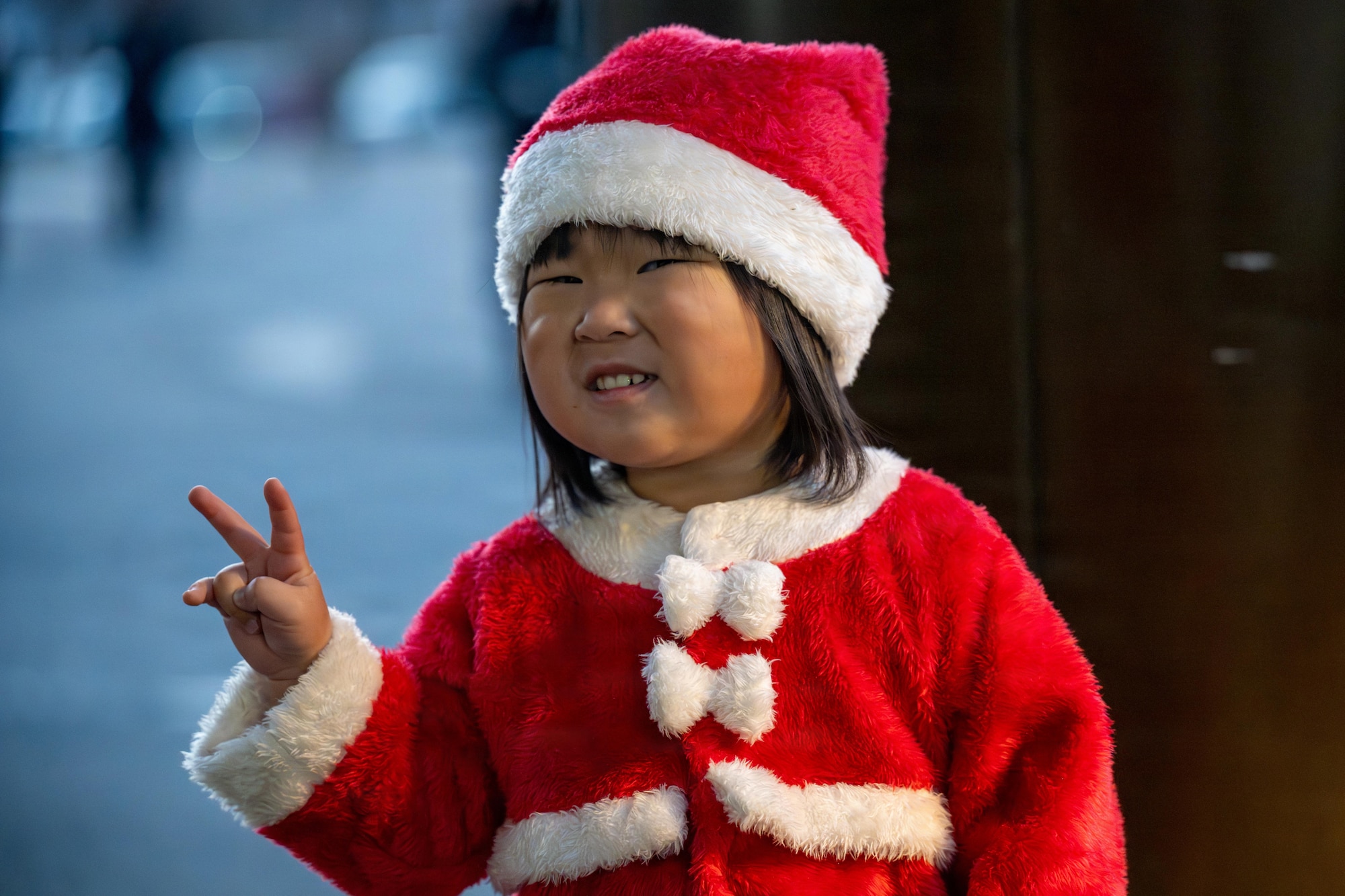 A participant dressed as Santa Claus poses for a photo during a tree lighting ceremony.