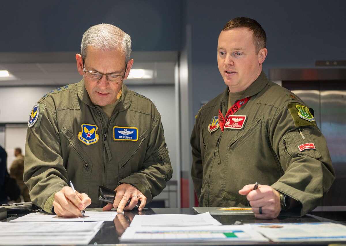 Two military members complete paperwork.