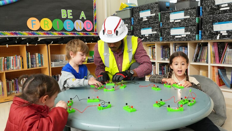 U.S. Army Corps of Engineers Japan District (USACE JED) engineering division civil engineer, Joseph Dashiell, center, assists students from Naval Air Facility Atsugi’s Shirley Lanham Elementary School in building electrical circuits during their annual Science Technology Engineering Art and Mathematics (STEAM) Day event, December 3rd, 2025. As part of the Department of Defense Education Activity (DoDEA) curriculum, Lanham’s STEAM Day introduces students to the dynamic world of STEAM through fast-paced, rotating classroom sessions led by guest instructors. Each session offers students a chance to see how science, technology, engineering, art, and mathematics intersect in everyday life. Photo by Patrick Ciccarone.