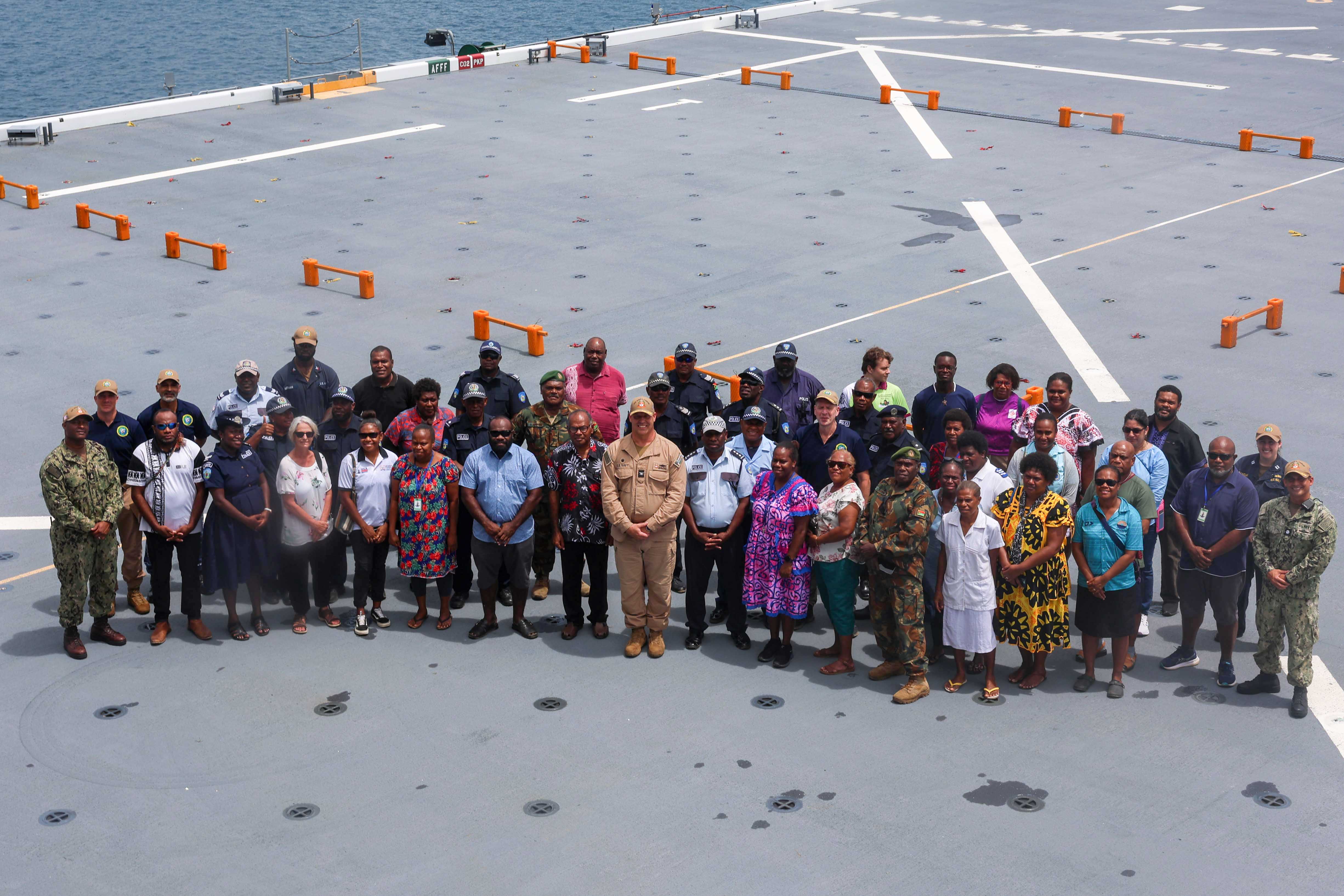 Participants of a ship tour aboard the Lewis B. Puller-class expeditionary sea base USS John L. Canley (ESB 6), pose for a group photo while the ship is moored in Luganville, Vanuatu, in support of Pacific Partnership 2025, Nov. 13.